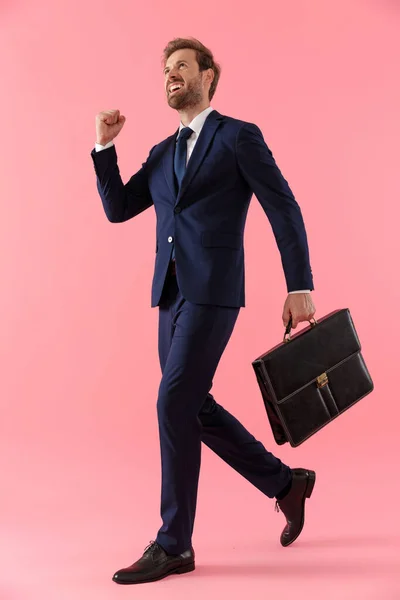 Freudiger Geschäftsmann, der eine Aktentasche in der Hand hält und feiert, schreit — Stockfoto