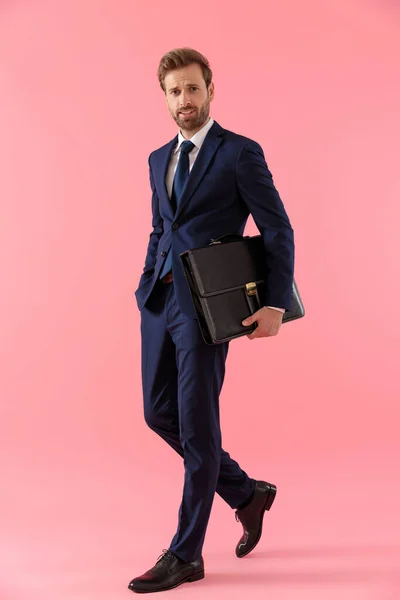 Confident businessman holding a briefcase and his hand in pocket — Stock Photo, Image