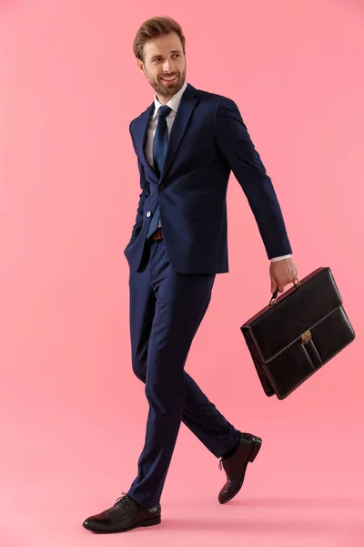 Affascinante uomo d'affari che tiene una valigetta e la mano in tasca — Foto Stock