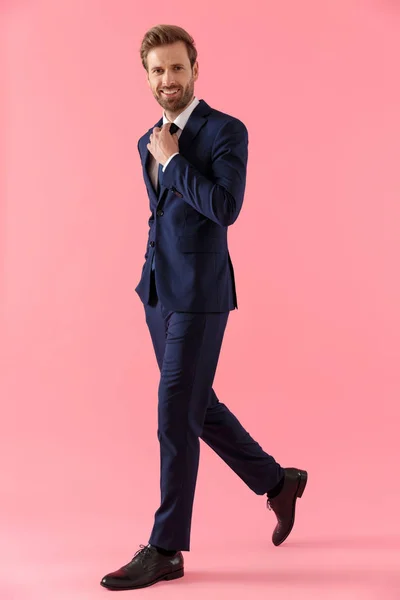 Charming businessman adjusting his tie and smiling — Stock Photo, Image