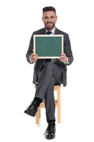 Szczęśliwy młody biznesmen trzyma zieloną tablicę — Zdjęcie stockowe
