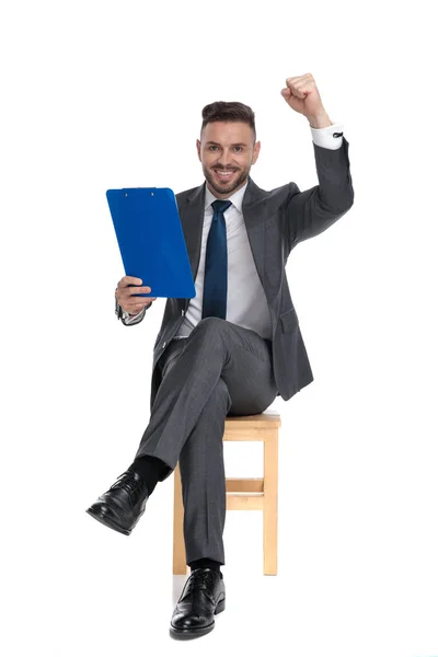 Jovem empresário feliz segurando prancheta — Fotografia de Stock