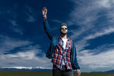 Yakışıklı genç adam elini havada tutuyor. 