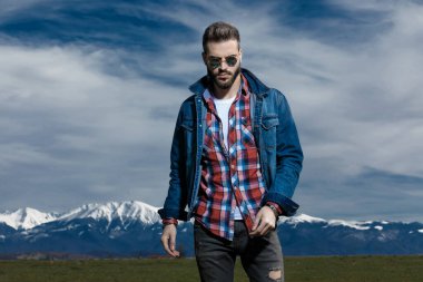 Kot ceket ve güneş gözlüğü takarken sert adam.