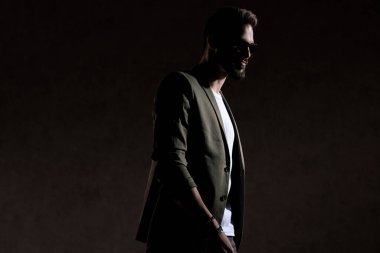 Mutlu havalı adam stüdyoda moda bir şekilde yürüyor.