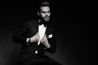 İş adamı oturuyor ve tutumuyla tasmayı düzenliyor.