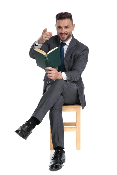 Elegante hombre de negocios sosteniendo libro y señalando el dedo — Foto de Stock