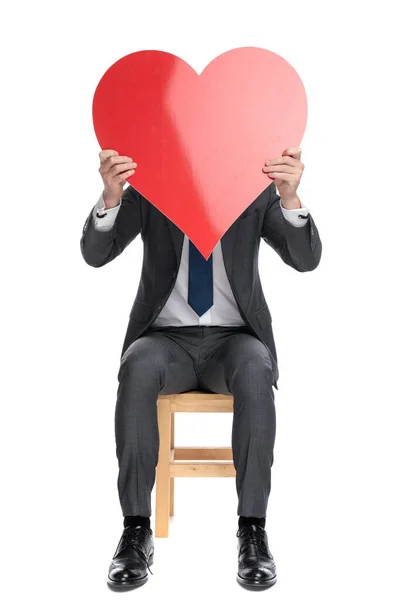 Elegante forretningsmand gemmer sig bag store røde hjerte - Stock-foto
