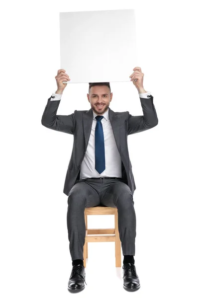 Feliz joven empresario sosteniendo tablero vacío — Foto de Stock