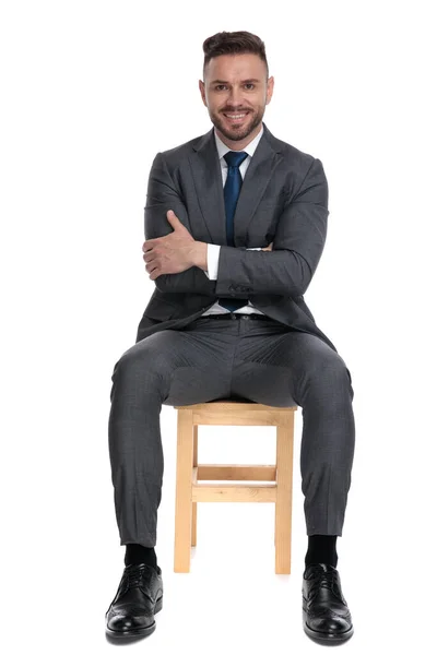 Feliz joven hombre de negocios cruzando brazos y sonriendo —  Fotos de Stock