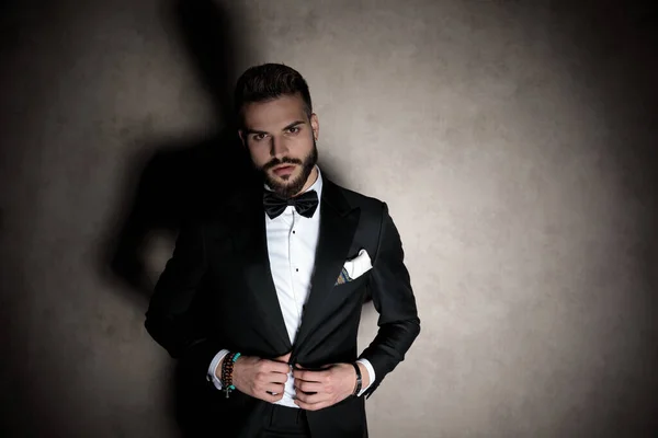 Confident groom adjusting his jacket and looking forward — Stock Photo, Image