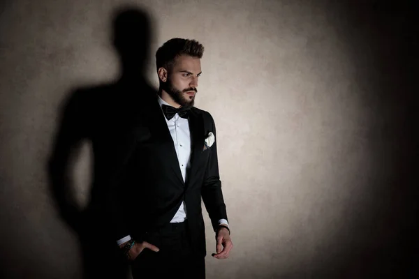 Upset groom holding his hand in his pocket and frowning — Stock Photo, Image