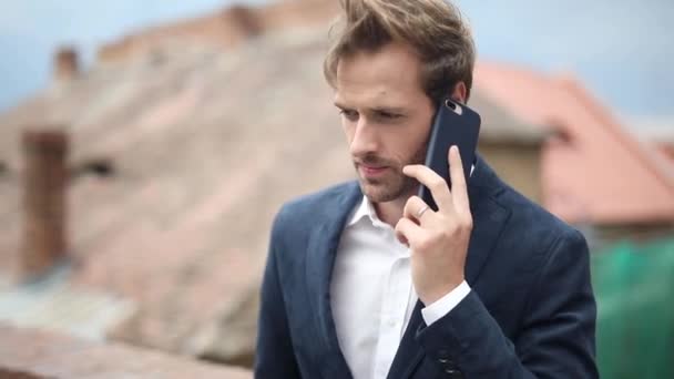 Young casual man talking on the phone and then looking at the screen to read a new message — Stock Video