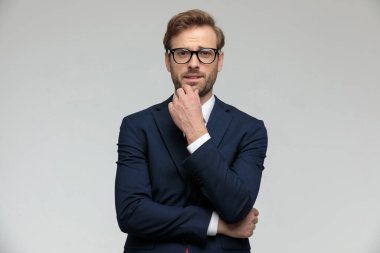businessman standing and pondering a decision pensive