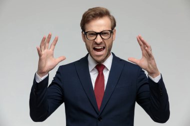 businessman standing and holding hands up angry