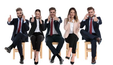 5 happy businessmen giving thumbs up and talking on phone 