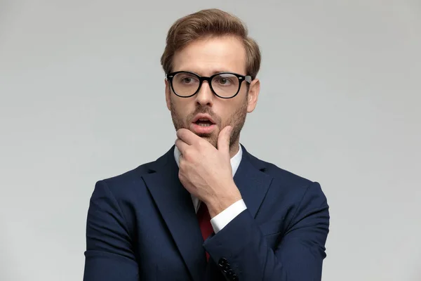 Businessman standing and looking away pensive and shocked — Stockfoto