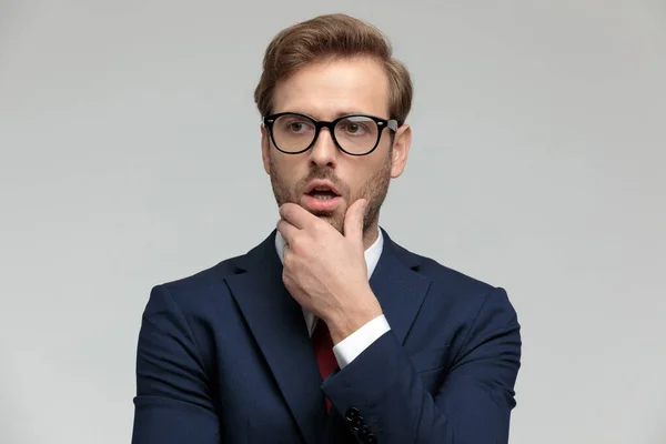 Businessman standing and looking away pensive and shocked — ストック写真