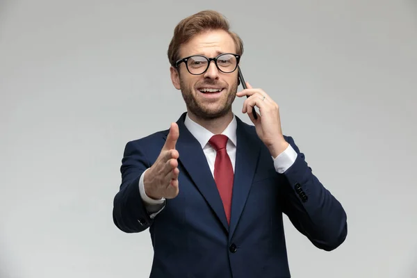 Businessman talking on the phone ready to shake hands — Stockfoto