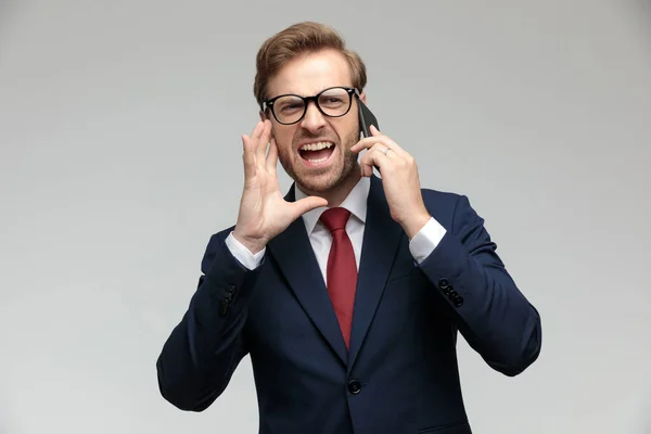 Businessman standing and yelling on the phone angry — Stockfoto