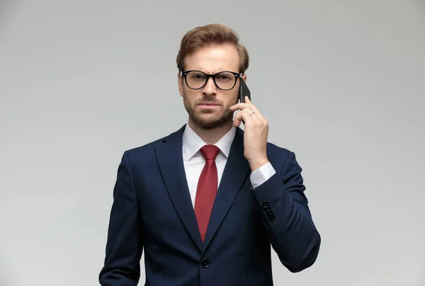 Hombre de negocios hablando por teléfono mientras mira la cámara enojado —  Fotos de Stock