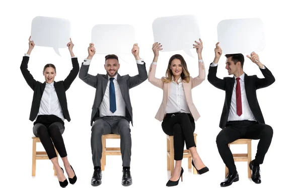 4 businessmen holding empty speech bubbles above their heads — Stockfoto