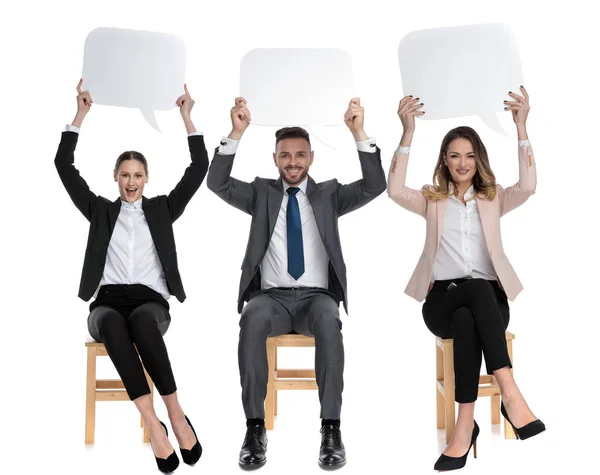 3 happy businessmen holding speech bubble above their heads — Stockfoto