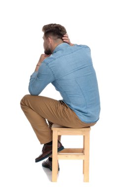 thoughtful young man holding hand to chin and thinking