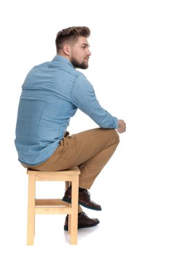 casual young guy in denim shirt looking to side