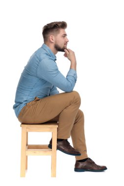 thoughtful casual guy holding hand to chin and thinking