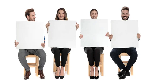 Команда з чотирьох щасливих бізнесменів тримає порожні рекламні щити — стокове фото