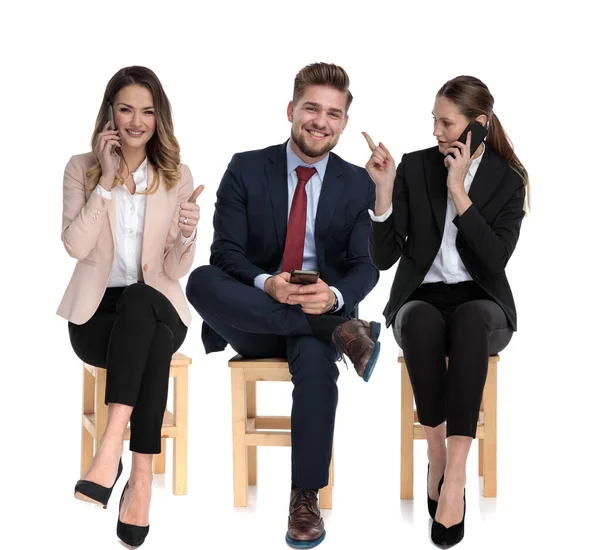 3 hombres de negocios sosteniendo sus teléfonos, señalando y dando pulgar hacia arriba — Foto de Stock