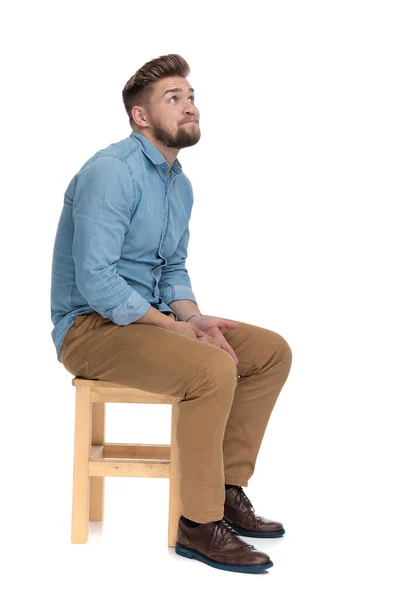 Cute young guy in denim shirt looking up and praying — Stockfoto