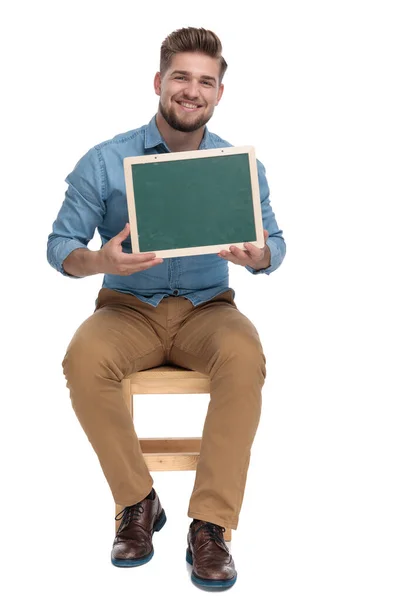 Happy casual man smiling and holding empty board — Stock Photo, Image