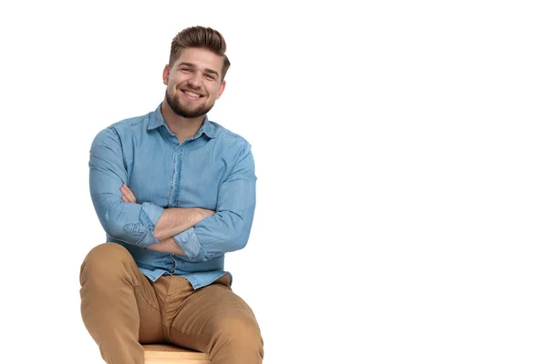 Hombre casual feliz en camisa de mezclilla sonriendo y cruzando brazos —  Fotos de Stock