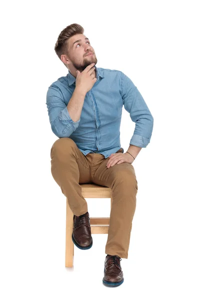 Modelo joven casual en camisa de mezclilla cogida de la mano a la barbilla —  Fotos de Stock