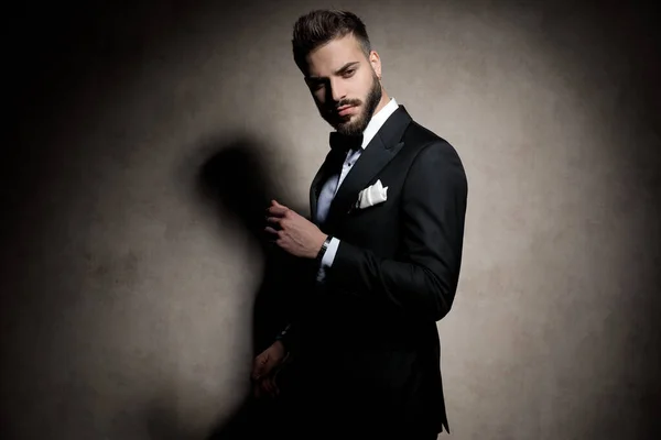 Sexy elegant young model in tuxedo holding hand in a fashion pos — Stock Photo, Image