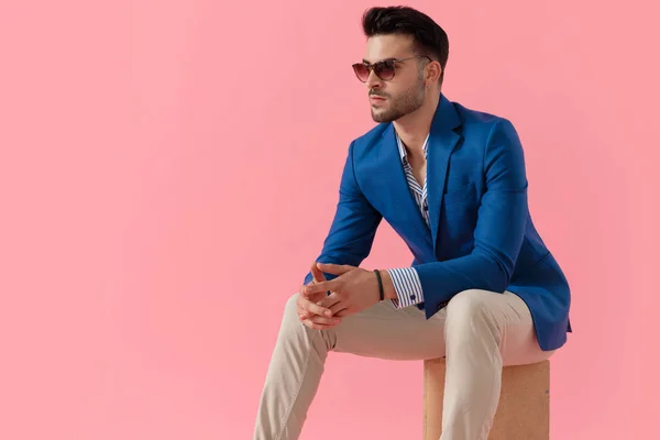 Sexy smart casual guy holding elbow on knees — Stock Fotó