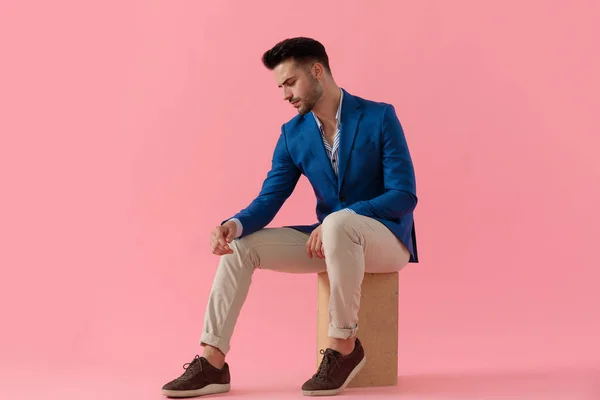 Young smart casual man holding elbow on knee — Stock fotografie