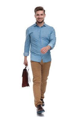 Çantayı tutarken gülümseyen ve beyaz stüdyo geçmişine basan kendine güvenen sıradan bir adam.