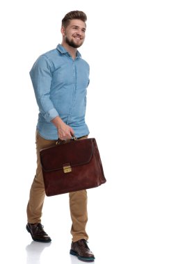 Evrak çantası tutarken gülen ve beyaz stüdyo geçmişine basan neşeli, sıradan bir adam.