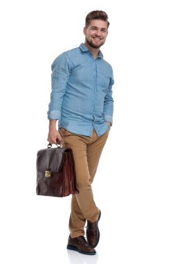 Çantayı ve el ele tutuşup, beyaz stüdyo arka planında dururken güzel bir gülüş.