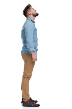 Mutlu, sıradan bir adamın gülümseyen ve yukarı bakan beyaz stüdyo arka planında duran