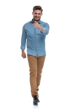 Beyaz stüdyo geçmişine bakarken ileri doğru bakıp gülen mutlu bir adam.