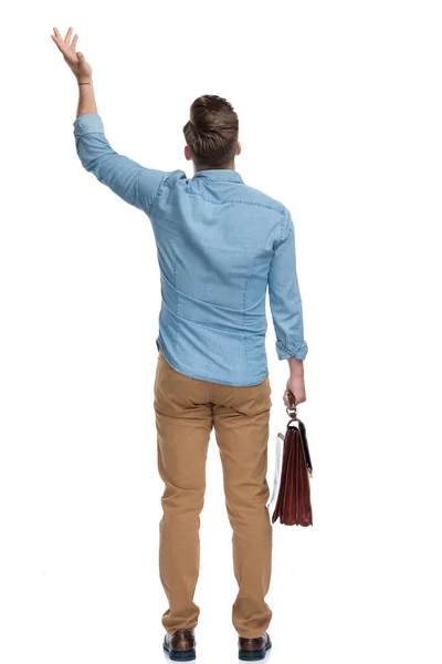 Οπίσθια Όψη Ενός Αναρωτιέται Casual Άνθρωπος Gesturing Και Κρατώντας Χαρτοφύλακα — Φωτογραφία Αρχείου