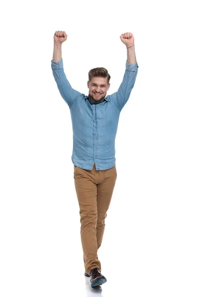 快乐而随意的男人一边在空中用双手庆祝 一边踩着白色的工作室背景 — 图库照片