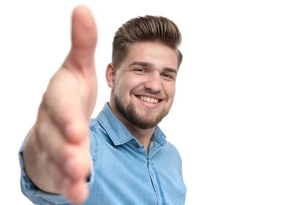 Alegre Homem Casual Sorrindo Chegando Aperto Mão Sobre Fundo Estúdio — Fotografia de Stock