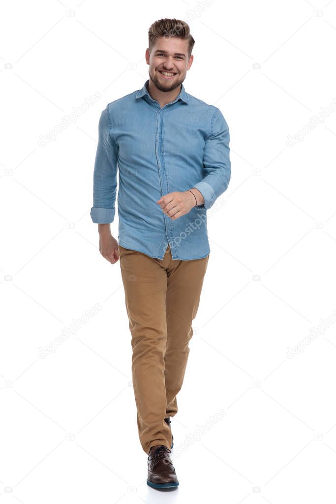 Cheerful casual man laughing while stepping on white studio background