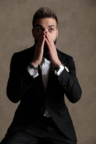 Surprised Groom Covering His Mouth Gasping While Wearing Tuxedo Sitting — Stock Photo, Image