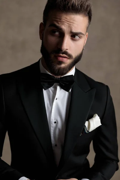 Yakışıklı Damat Smokin Giyerken Duvar Kâğıdı Stüdyo Arka Planında Bir — Stok fotoğraf